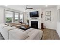 Cozy living room with a fireplace, large windows, a ceiling fan, and comfortable seating at 404 Porterfield Dr, Youngsville, NC 27596