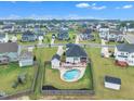 Aerial view of a private backyard with an in-ground pool, patio seating, and a wooden fence within a friendly neighborhood at 450 S Parliament Way, Clayton, NC 27520