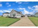 Well-maintained home featuring a spacious three-car garage, a long driveway, and an extra detached garage space at 450 S Parliament Way, Clayton, NC 27520
