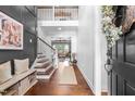 Inviting foyer with hardwood floors, paneled walls, staircase, bench, and natural light at 4621 Basilica Dr, Holly Springs, NC 27540