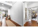 Bright hallway featuring hardwood floors, white trim, and a view into the living room and office at 4621 Basilica Dr, Holly Springs, NC 27540