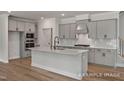Modern kitchen boasts gray cabinets, a spacious center island, quartz countertops, and stainless steel appliances at 4824 Bristol Meadow Dr, Raleigh, NC 27603