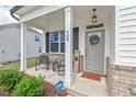 Inviting front porch with seating area, welcoming wreath, and charming 'welcome home' rug at 509 Rain Drizzle Ct, Wake Forest, NC 27587