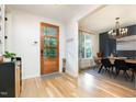 Bright foyer featuring a wood front door, hardwood floors, and a glimpse into the dining area at 517 Bart St, Raleigh, NC 27610