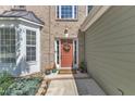 Inviting front entrance with a decorative wreath and colorful potted plants at 5603 Whisperwood Dr, Durham, NC 27713