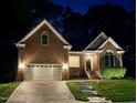 Beautifully lit brick home at night with a well-manicured lawn at 6313 Belle Crest Dr, Raleigh, NC 27612