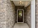 Inviting entryway featuring stone walls, a modern light fixture, and a glass-paneled front door at 640 Barneswyck Dr, Fuquay Varina, NC 27526