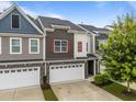 Charming townhouse showcasing a two-car garage, neutral siding, and complemented by mature trees at 640 Barneswyck Dr, Fuquay Varina, NC 27526