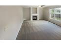 Spacious living room featuring a fireplace and large windows that allow natural light to illuminate the area at 6701 Winding Arch Dr, Durham, NC 27713