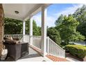 Inviting covered front porch with white columns and brick steps offers tranquil outdoor seating at 705 Harkness Cir, Durham, NC 27705