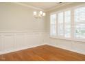 Dining room with hardwood floors, wainscoting, plantation shutters and elegant chandelier at 7646 Winners Edge St, Raleigh, NC 27617