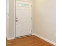 Clean entryway featuring hardwood floors and white door, offering a welcoming first impression at 7646 Winners Edge St, Raleigh, NC 27617