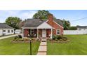 Charming brick home with a well-manicured lawn and cozy front porch during the day at 9964 N Chestnut St, Middlesex, NC 27557