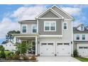 Charming two-story home with a two-car garage, covered porch, and landscaped front yard at 100 Emory Bluffs Dr, Holly Springs, NC 27540