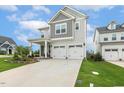 Charming two-story home with a two-car garage, covered porch, and landscaped front yard at 100 Emory Bluffs Dr, Holly Springs, NC 27540