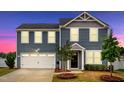 Charming two-story home featuring a two-car garage, black door, and well-manicured front yard at 1004 Summer Mist Ln, Durham, NC 27704