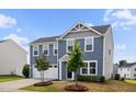 Beautiful blue two-story home with a two-car garage and manicured front yard at 1004 Summer Mist Ln, Durham, NC 27704