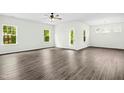 Spacious living room featuring ample natural light, wood-look floors, and modern ceiling fan at 107 Altair Ln, Sanford, NC 27330