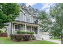 Charming two-story home with a welcoming front porch, manicured lawn and attached two car garage at 1138 Bexley Hills Bnd, Apex, NC 27502