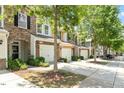 Street view of the townhome complex features mature trees and well-maintained exteriors with garages at 1213 Silver Beach Way, Raleigh, NC 27606