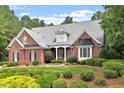 Traditional brick home featuring a well-maintained lawn, mature trees, and inviting front entrance at 122 Barringer Dr, Garner, NC 27529