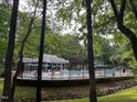 Community pool surrounded by a wrought iron fence, umbrellas, and lounge chairs for residents at 1300 Seabrook Ave, Cary, NC 27511