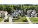 Expansive aerial view showcasing the home's setting amongst lush greenery and manicured lawn at 1325 Mackinaw Dr, Wake Forest, NC 27587