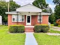 Charming single-story red brick home featuring a cozy front porch and well-maintained landscaping at 1337 Maple St, Rocky Mount, NC 27803