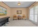 Cozy living room with neutral carpeting, large windows, and elegant furnishings, featuring a piano at 15 Smoketree Ct, Durham, NC 27712