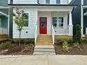 Close-up view of the entry to a delightful home showing the striking red front door and concrete steps at 1907 Plott Balsam Dr, Wendell, NC 27591
