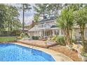 Beautiful backyard featuring a sparkling pool, wooden deck, and a charming two-story home at 1913 Fawndale Dr, Raleigh, NC 27612