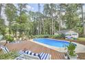 Inviting backyard with a sparkling pool, wooden deck, and ample seating for outdoor relaxation at 1913 Fawndale Dr, Raleigh, NC 27612