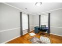 Bright home office with hardwood floors, featuring a modern desk, stylish chairs, and plenty of natural light at 213 Bracken Ct, Raleigh, NC 27615
