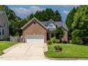 Beautiful two-story brick home with a well-maintained lawn, mature trees and attached two car garage at 2302 Fordcrest Dr, Apex, NC 27502
