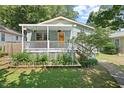 Quaint home featuring a covered porch adorned with hanging plants and a well-manicured lawn at 2322 Stroller Ave, Durham, NC 27705