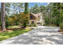 Home exterior featuring a long driveway, two-car garage, and beautifully landscaped yard at 240 Oak Grove Church Rd, Youngsville, NC 27596