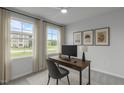 Bright home office featuring a modern desk setup, large windows, and neutral decor creating a productive workspace at 2539 Kasota Ln, Raleigh, NC 27610