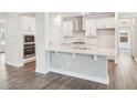 Bright kitchen with modern design, featuring white cabinetry, stainless steel appliances, and a stylish breakfast bar at 2613 Red Spruce Dr, Raleigh, NC 27616