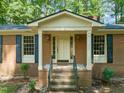 Close-up of brick home featuring a classic front porch with columns, steps and dark shutters at 3006 Pump Station Ln, Durham, NC 27712