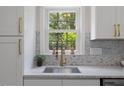 Kitchen sink with view out the window, marble backsplash and modern faucet at 308 Greenwood Dr, Durham, NC 27704