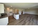 Modern kitchen featuring stainless steel appliances, an island with granite countertops, and hardwood flooring throughout the area at 37 Chloe Ct, Selma, NC 27576