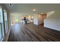 Bright living room with hardwood floors and white cabinets featuring an island and a staircase in the background at 37 Chloe Ct, Selma, NC 27576