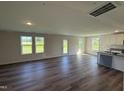 Spacious living room featuring hardwood floors, large windows, and a neutral color palette, perfect for entertaining at 37 Chloe Ct, Selma, NC 27576