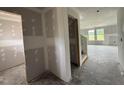Unfinished living room with ample natural light from large windows; ready for customization at 37 Chloe Ct, Selma, NC 27576