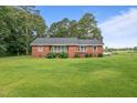 Brick home featuring a lush lawn, complemented by hydrangeas and a classic design at 445 Lee County Line Rd, Broadway, NC 27505