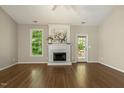 Cozy living room with a fireplace, hardwood floors, and a door leading to the outdoor deck at 4619 Regency Dr, Durham, NC 27713