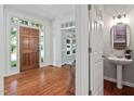 Foyer with wooden door, transom window, hardwood floors, and a view into the adjoining office space at 5109 Windance Pl, Holly Springs, NC 27540