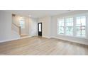 Inviting living room with large windows, light wood floors, and modern trim at 524 Folk Song Way, Wendell, NC 27591