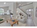 Open-concept living room with modern decor, hardwood floors, and staircase to upper level at 5308 Bentgrass Dr, Raleigh, NC 27610