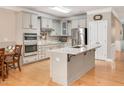 Beautiful kitchen featuring white cabinetry, stainless steel appliances, an island, and modern lighting at 5637 Garnet Meadow Rd, Knightdale, NC 27545